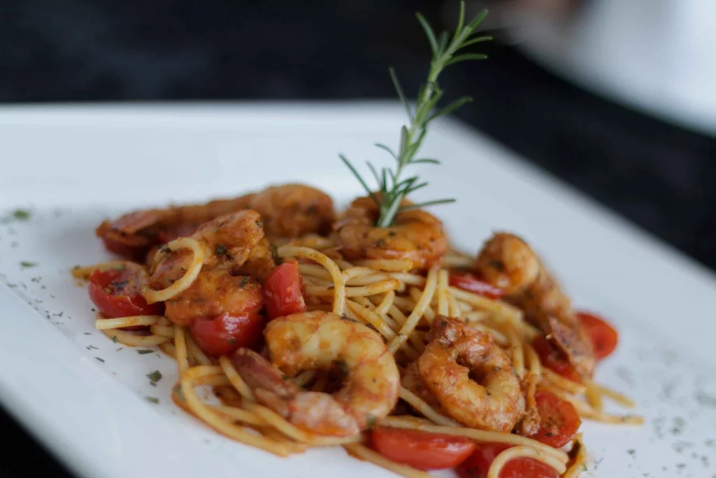 Camarão grelhado flambado no conhaque com molho à Provençal. Acompanha spaghetti no próprio molho